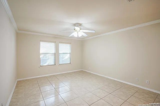 an empty room with windows and chandelier fan