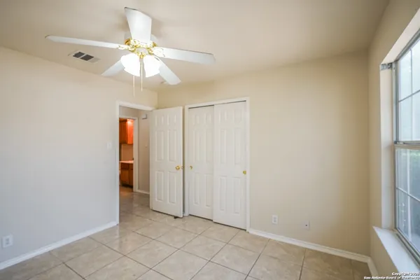an empty room with fan and windows