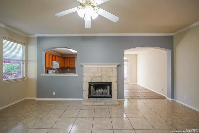 an empty room with windows and fireplace