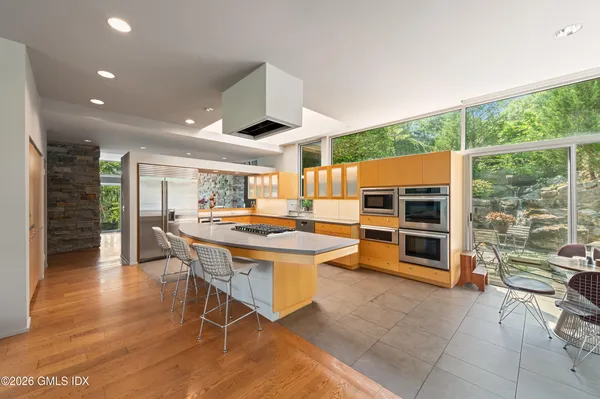 a kitchen with stainless steel appliances kitchen island granite countertop a table and chairs in it