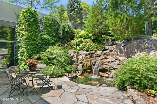 a patio with table and chairs and potted plants