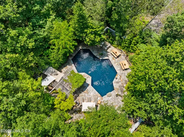 a aerial view of a house with a yard and large trees