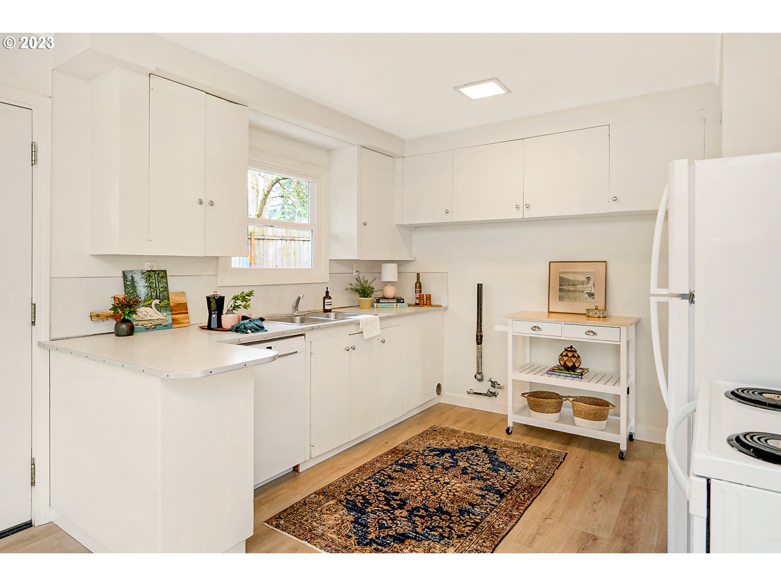 8900 Southwest 69th Avenue Portland, OR 97223 - Photo 11 of 31 a kitchen with a refrigerator and white cabinets