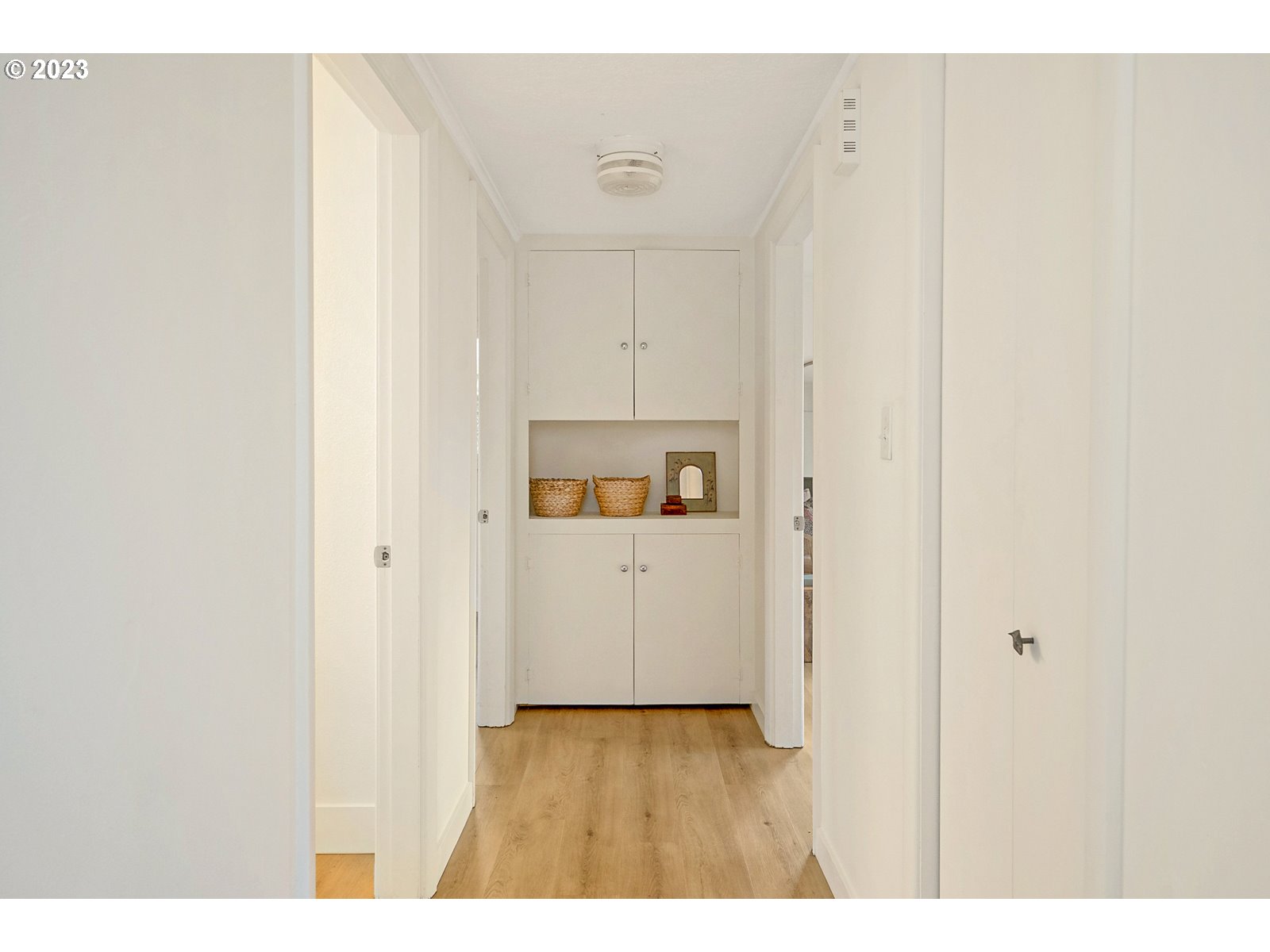 8900 Southwest 69th Avenue Portland, OR 97223 - Photo 15 of 31 a view of a hallway with white cabinets and wooden floor