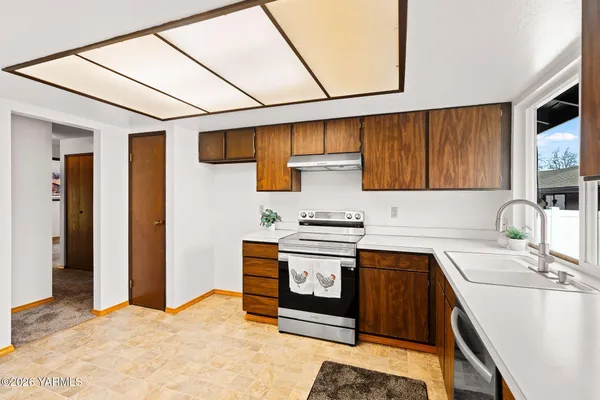 a kitchen with stainless steel appliances granite countertop a sink stove and cabinets