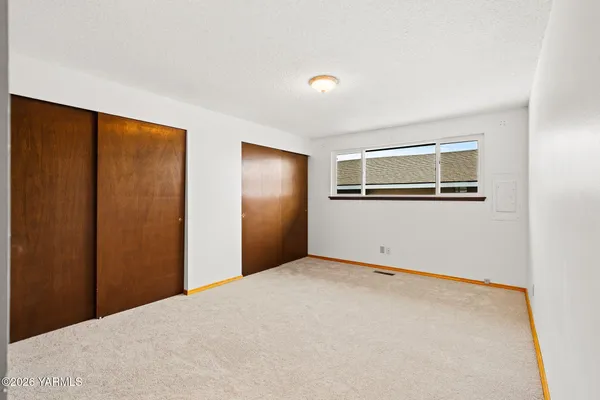 a view of a big room with closet and windows