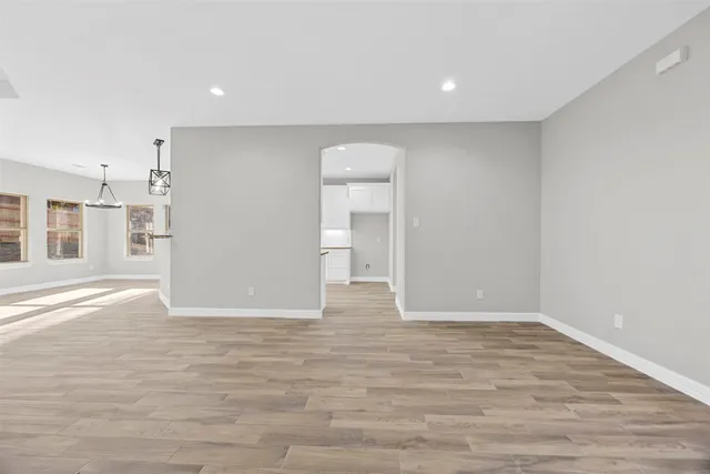 a view of empty room with wooden floor