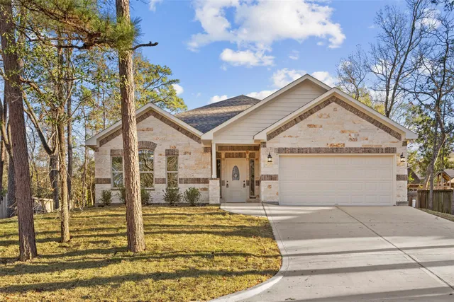 a view of a white house with a large tree