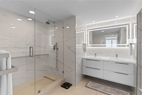 a bathroom with a shower sink and mirror