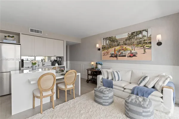 a living room with furniture a rug and white walls