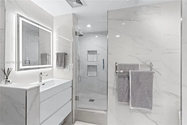 a bathroom with a shower sink and mirror