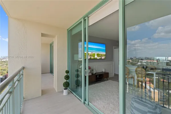 a view of a balcony with furniture and floor to ceiling window