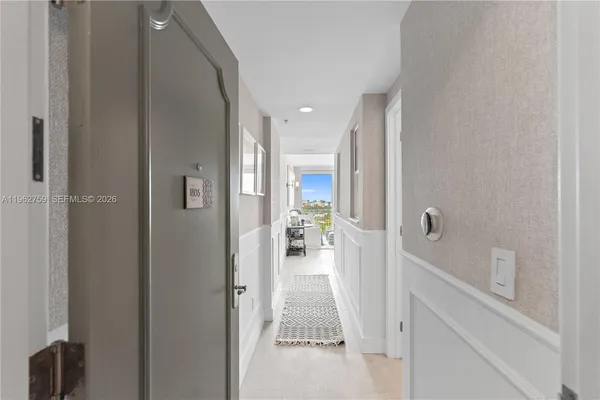 a hallway with white cabinets and wooden floor