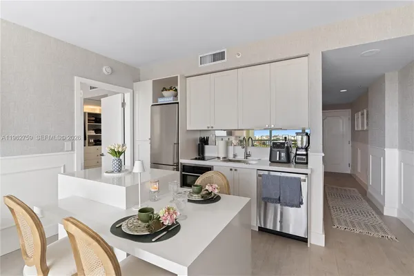 a kitchen with stainless steel appliances a table and chairs in it