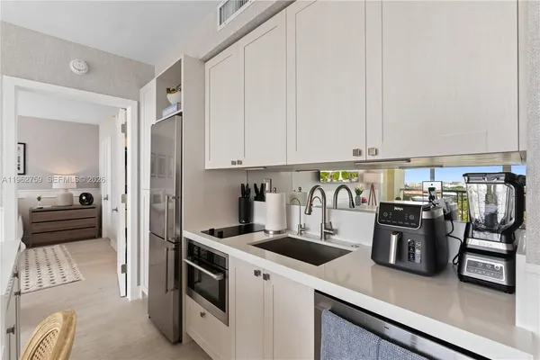 a kitchen with a refrigerator and white cabinets