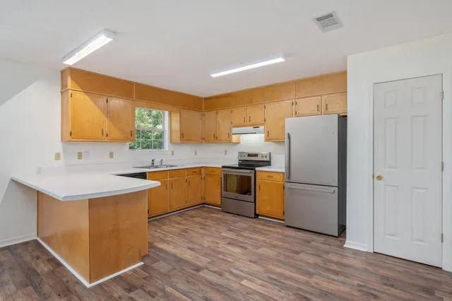 a kitchen with a sink a refrigerator a window and a counter top space