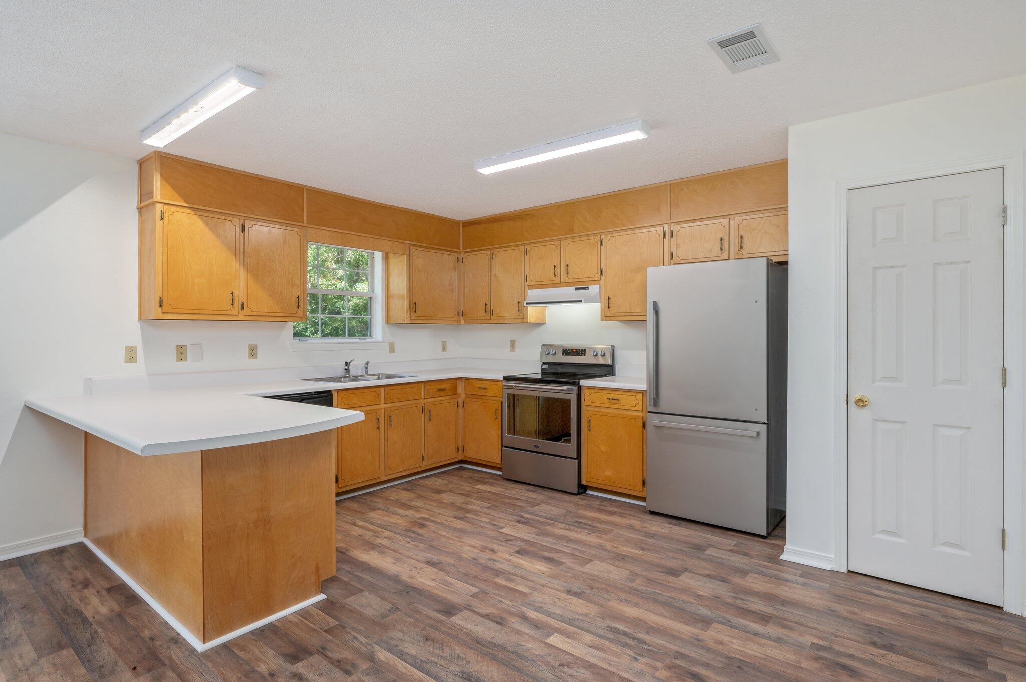 624 Hill Street DeFuniak Springs, FL 32435 - Photo 11 of 34 a kitchen with a sink a refrigerator a window and a counter top space
