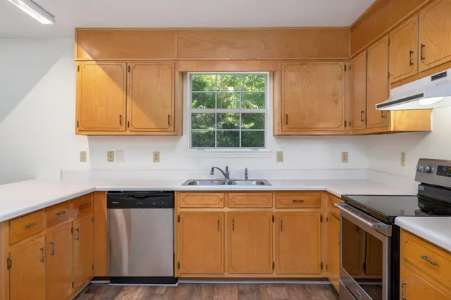 a kitchen with stainless steel appliances granite countertop a sink stove and cabinets