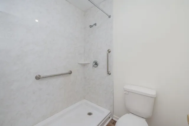 a bathroom with a toilet and a shower