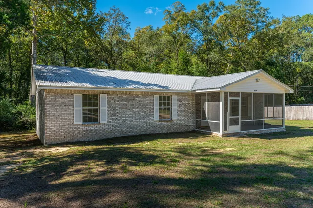 a view of a house with a yard potted plants and large tree
