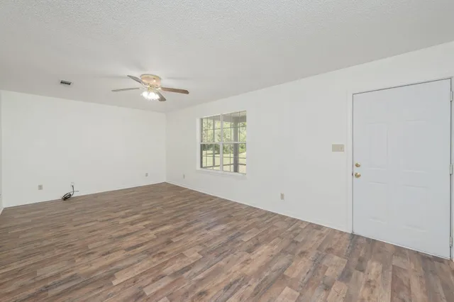 an empty room with fan and windows