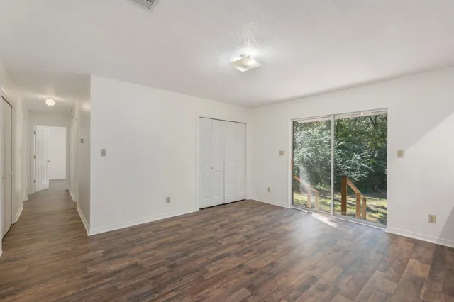 a view of a room with wooden floor and sliding glass door