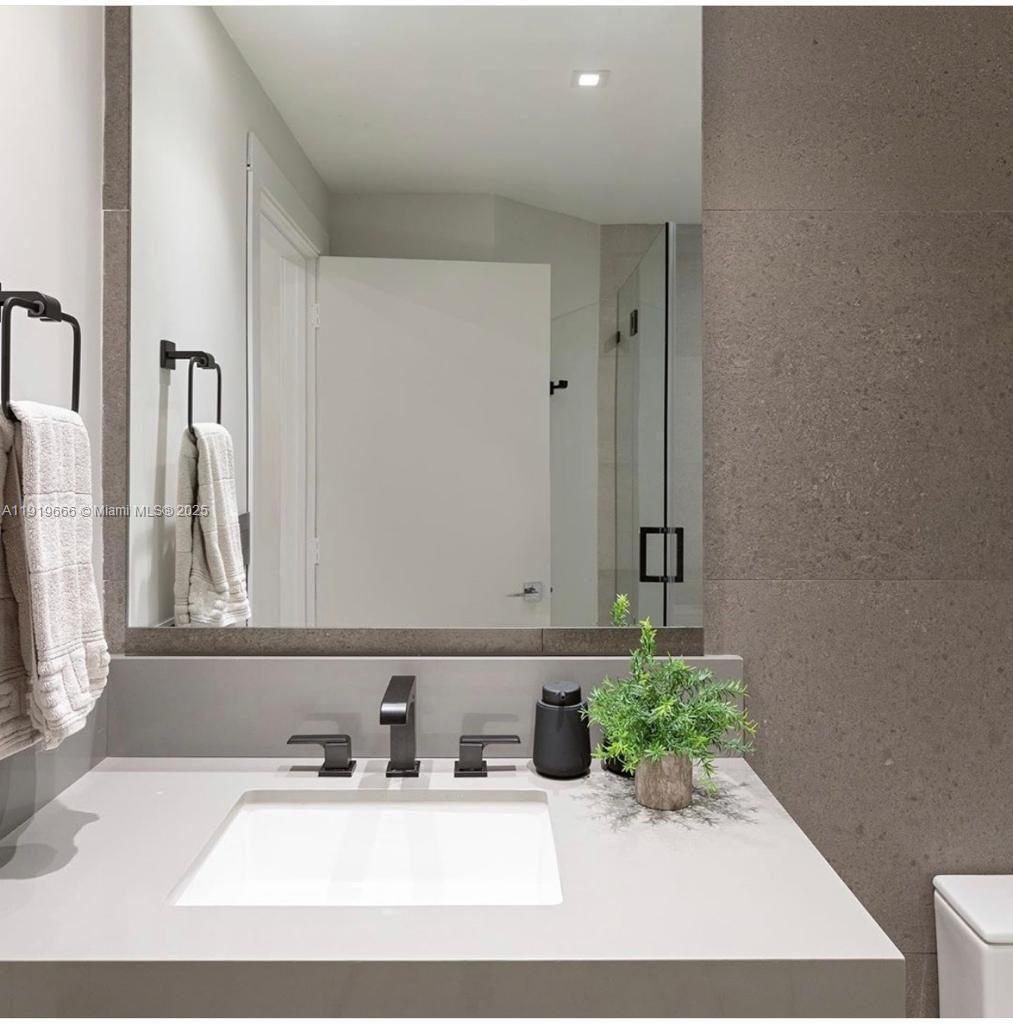 711 Crandon Boulevard, Unit 401 Key Biscayne, FL 33149 - Photo 13 of 29 a bathroom with a sink and a mirror