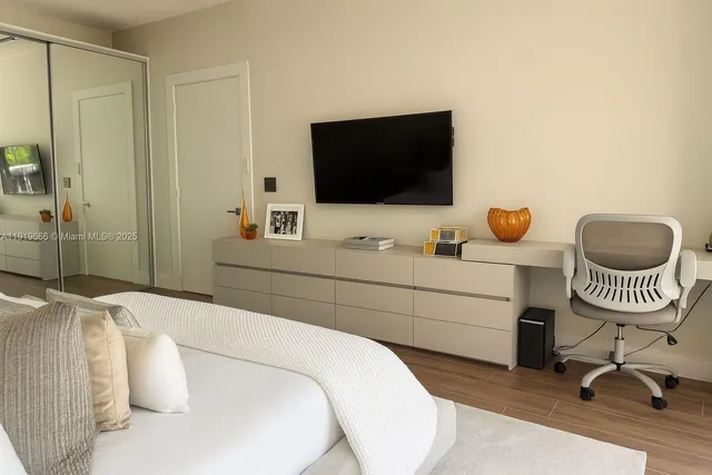 a bedroom with a bed and a flat screen tv
