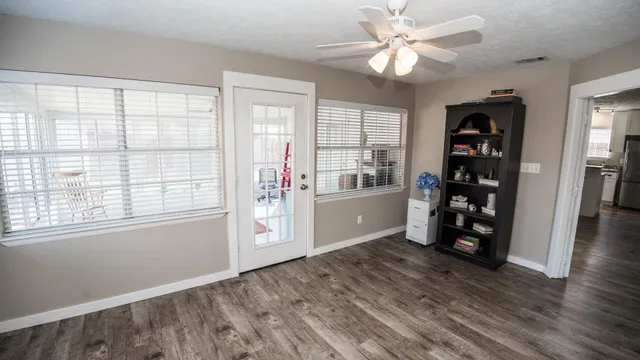 a view of an empty room with window and wooden floor