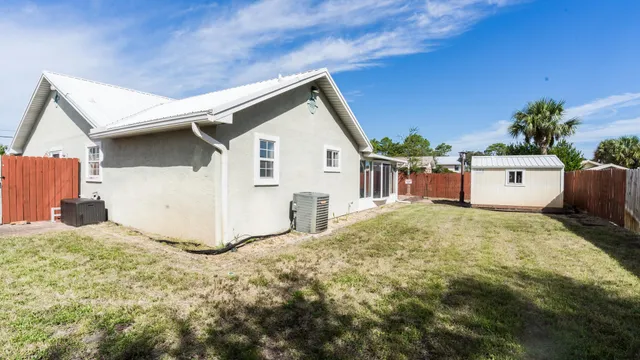 a view of a house with backyard and a tree
