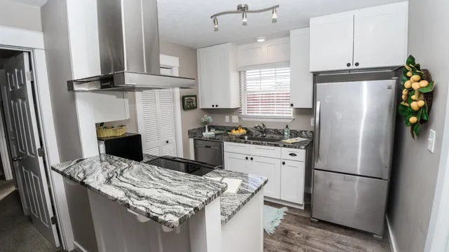 a kitchen with stainless steel appliances granite countertop a refrigerator a stove a sink dishwasher and a refrigerator