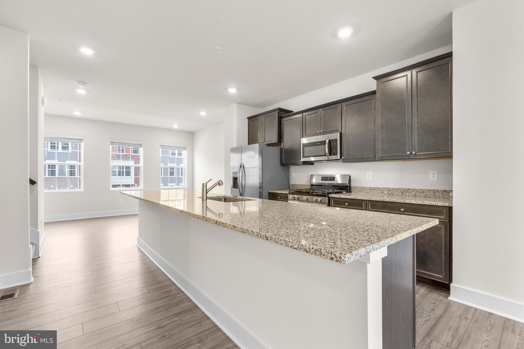 1826 Parham Way Windsor Mill, MD 21244 - Photo 11 of 37 a kitchen with stainless steel appliances granite countertop a sink stove and microwave