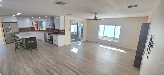 a view of kitchen with refrigerator stove and wooden floor
