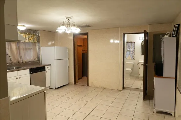 a kitchen with granite countertop white cabinets white appliances with a sink and dishwasher