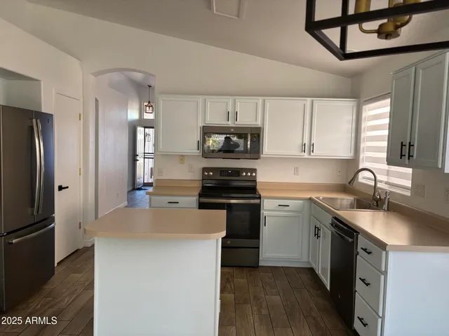 a kitchen with granite countertop a sink stove and refrigerator