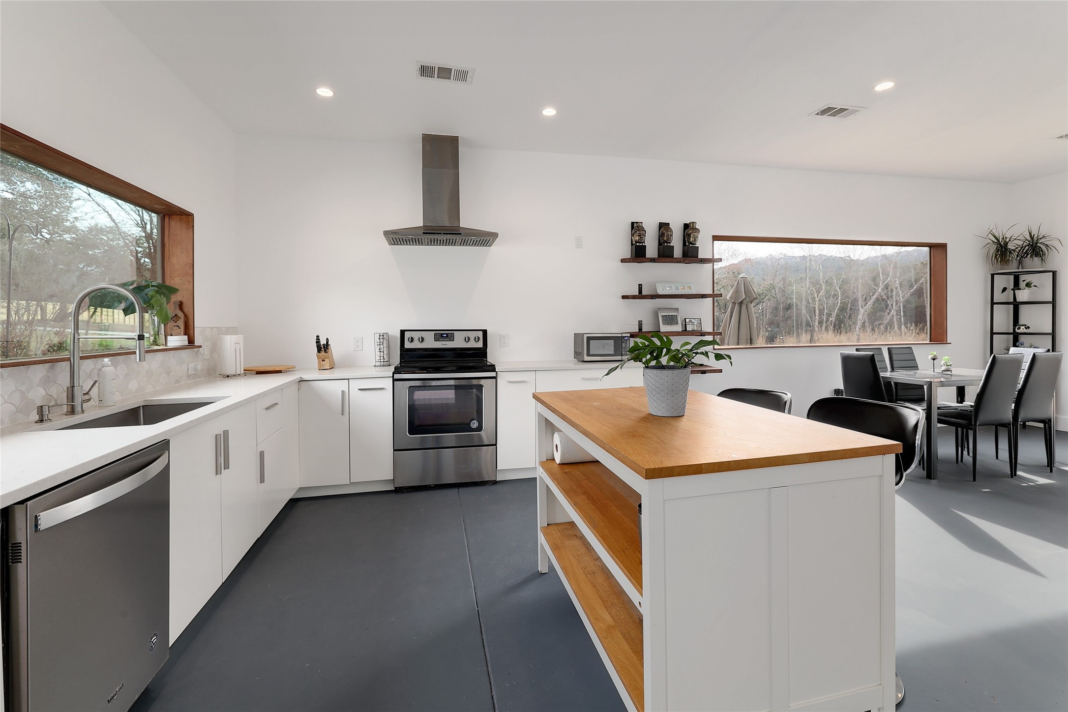 7001 Ranch Road 2222 Austin, TX 78730 - Photo 2 of 18 Culinary adventures await in this naturally illuminated kitchen, featuring sleek appliances and a delightful island.