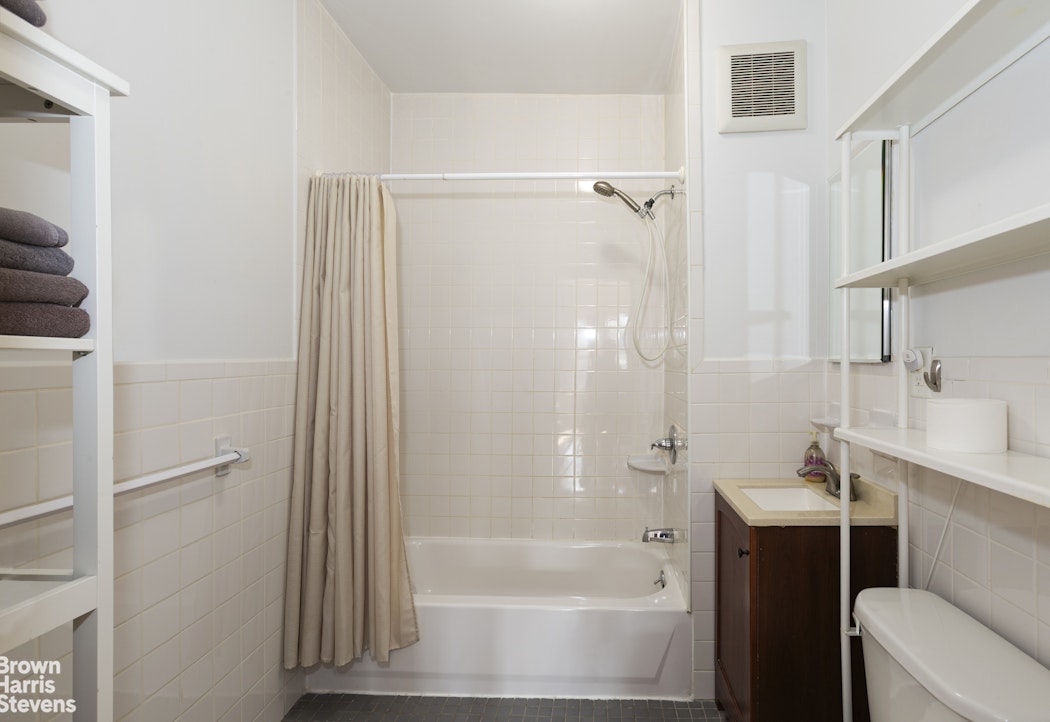 823 Union Street Brooklyn, NY 11215 - Photo 10 of 17 a bathroom with a bathtub shower sink vanity and toilet