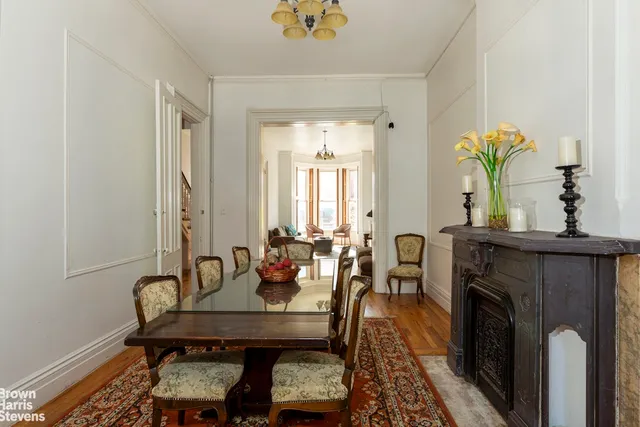 a dining room with furniture a rug a potted plant and a chandelier