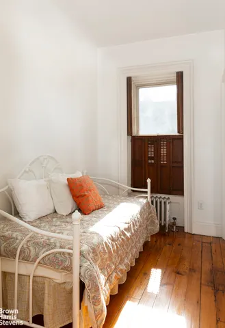 a bedroom with a bed and a large window