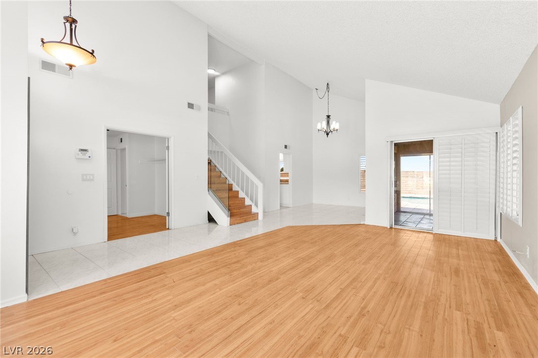 4430 Cranbrook Way Las Vegas, NV 89103 - Photo 8 of 50 Natural light streams into this generously sized living area, featuring soaring vaulted ceilings and sleek wood-look flooring.