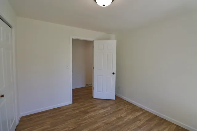 a view of an empty room with wooden floor