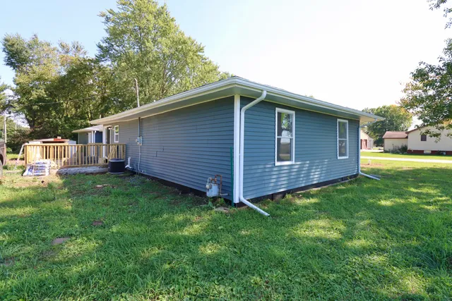 a view of a small house with backyard space and balcony