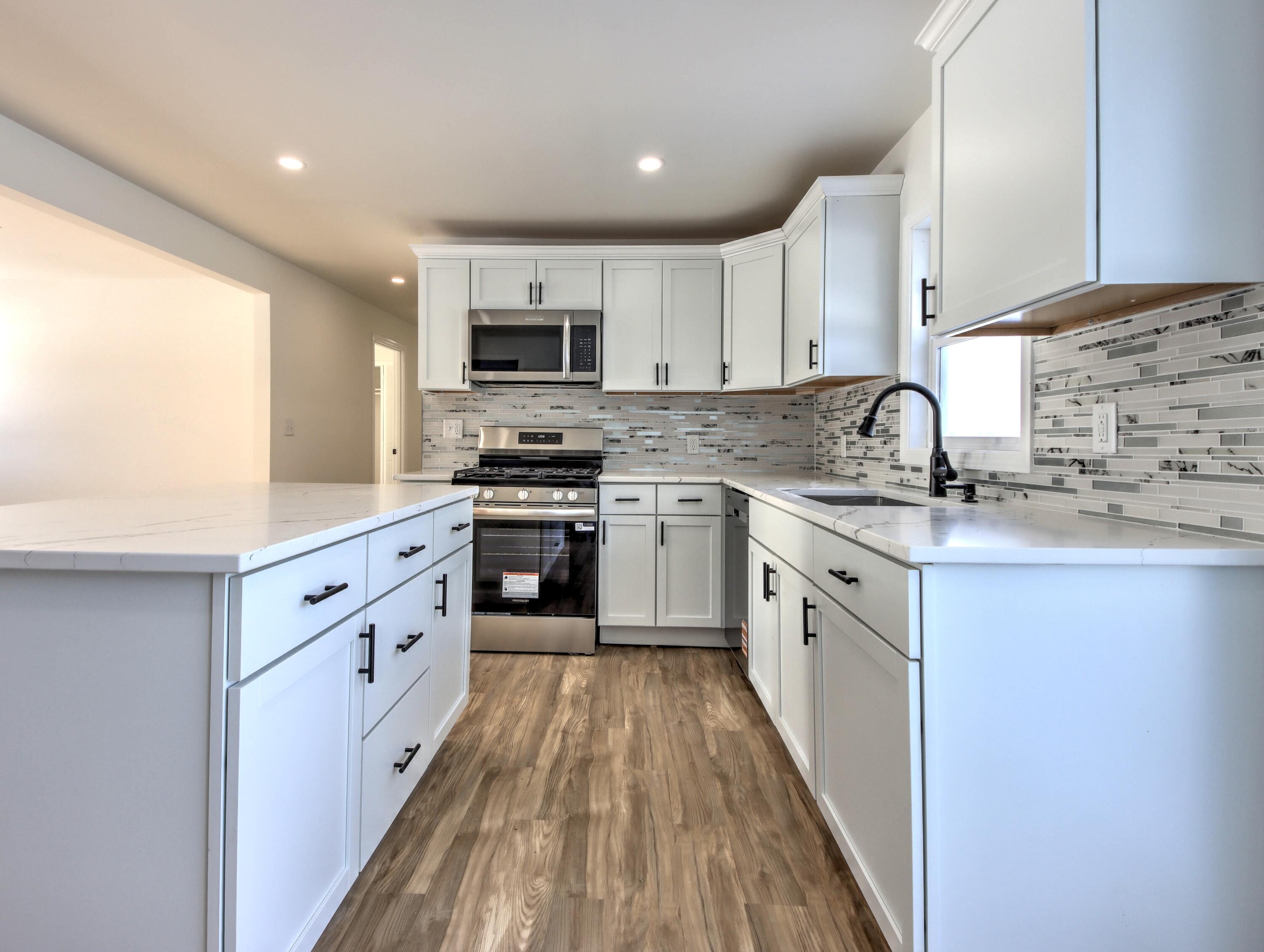 315 Holly Drive Walkerton, IN 46574 - Photo 8 of 33 a large kitchen with stainless steel appliances granite countertop a stove top oven a sink dishwasher and a refrigerator with wooden floor