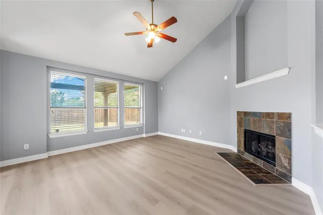 an empty room with windows and fireplace