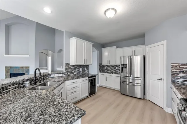 a kitchen with stainless steel appliances granite countertop a refrigerator sink and stove