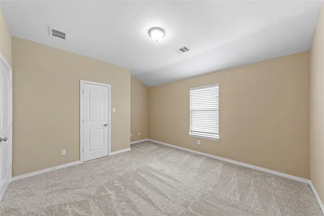 a view of an empty room with a window and closet area