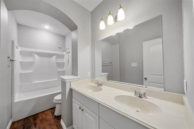 a bathroom with a sink a toilet and a mirror