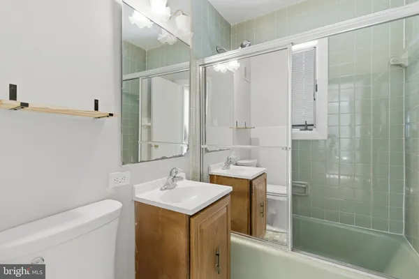 a bathroom with a shower sink vanity and mirror
