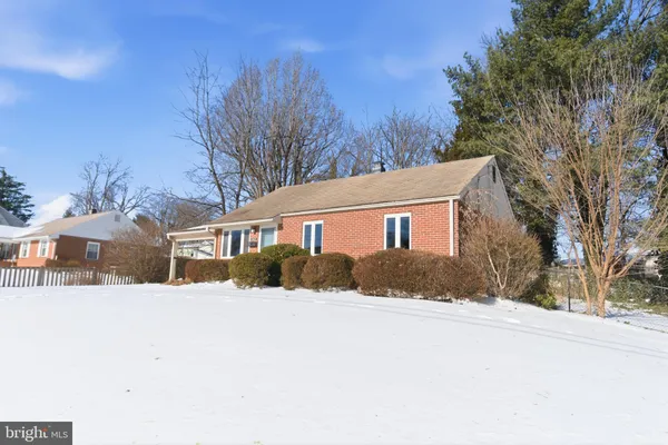 a view of a house with a yard covered in snow