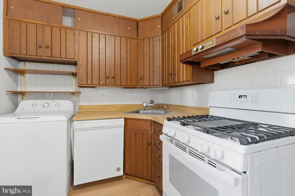 a white stove top oven sitting inside of a kitchen